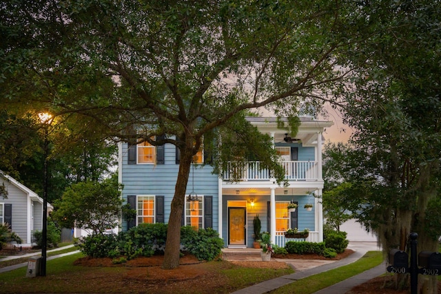view of front of property with a balcony, ceiling fan, and covered porch