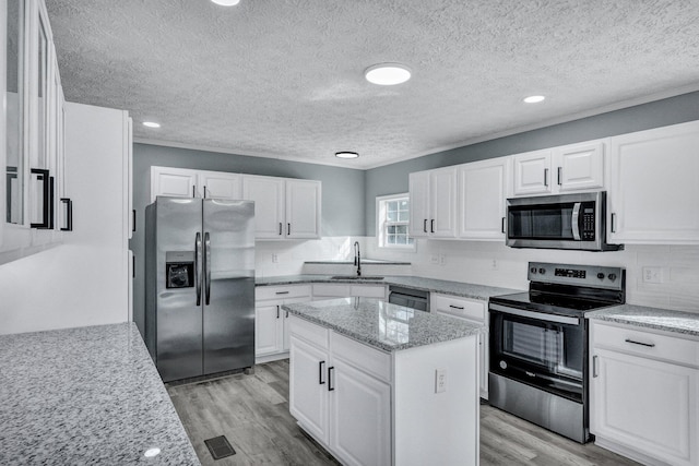 kitchen featuring stainless steel appliances, decorative backsplash, a sink, and light wood-style floors