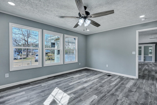 spare room featuring a textured ceiling, wood finished floors, a ceiling fan, baseboards, and ornamental molding