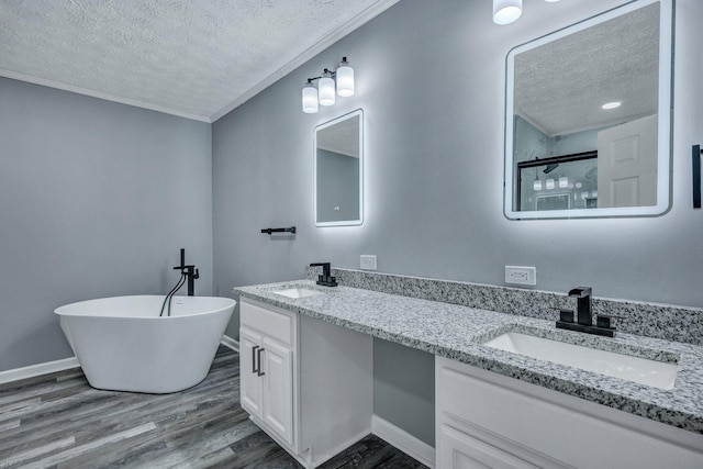 full bathroom featuring a shower stall, a textured ceiling, a sink, and wood finished floors