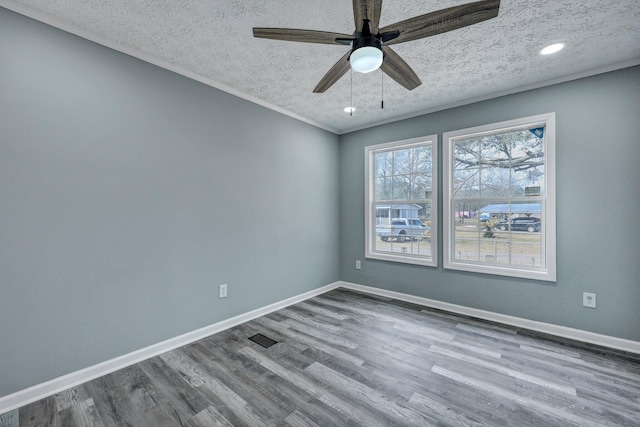 spare room with a ceiling fan, a textured ceiling, baseboards, and wood finished floors