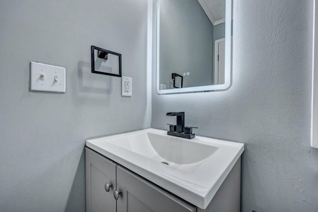 bathroom with a textured wall and vanity