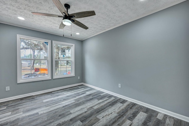 unfurnished room with a textured ceiling, baseboards, and wood finished floors