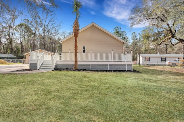 exterior space featuring a yard, a wooden deck, and fence