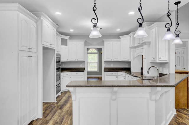 kitchen with white cabinets, stainless steel appliances, and hanging light fixtures