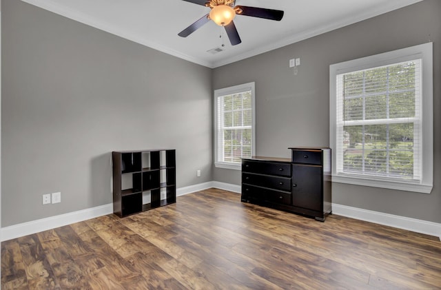 empty room with a wealth of natural light, crown molding, and ceiling fan