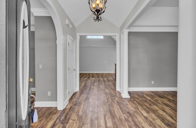 entrance foyer with a notable chandelier, dark hardwood / wood-style flooring, lofted ceiling, and crown molding