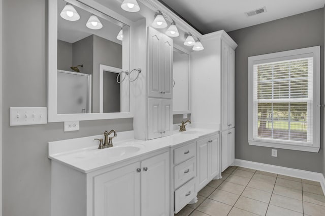 bathroom featuring tile patterned floors, vanity, and a shower with door