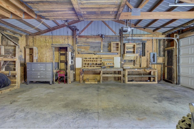 garage with a workshop area, electric panel, and a garage door opener