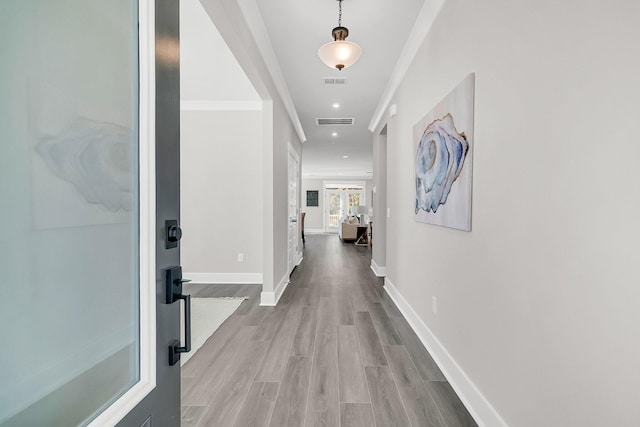 hall featuring hardwood / wood-style flooring and crown molding