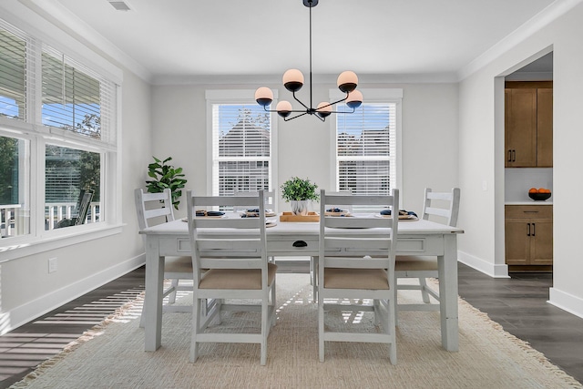 dining area featuring an inviting chandelier, crown molding, dark wood-type flooring, and a healthy amount of sunlight