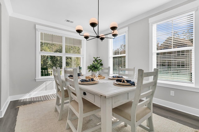 dining room with crown molding, an inviting chandelier, and dark hardwood / wood-style flooring