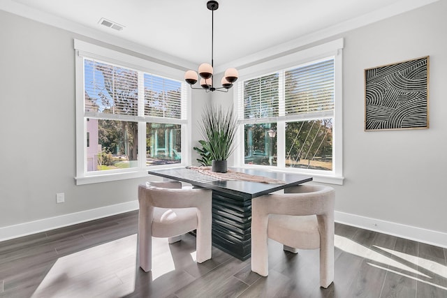 dining area featuring an inviting chandelier, a healthy amount of sunlight, and dark hardwood / wood-style flooring