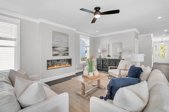 living room with hardwood / wood-style flooring, crown molding, and ceiling fan