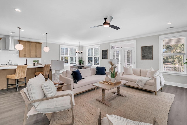 living room featuring french doors, ceiling fan, crown molding, and light wood-type flooring