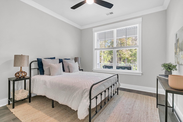 bedroom featuring hardwood / wood-style flooring, ceiling fan, and ornamental molding