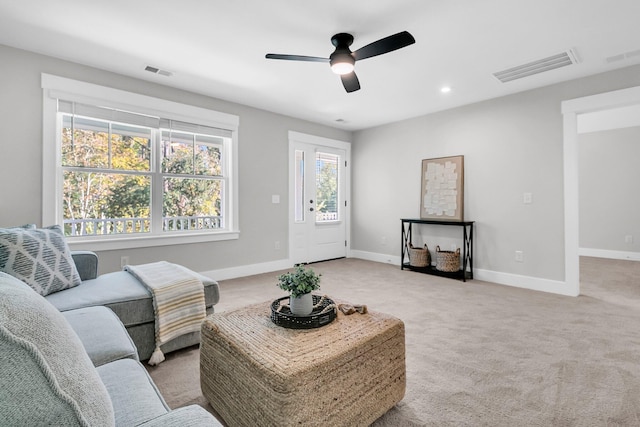 carpeted living room with ceiling fan