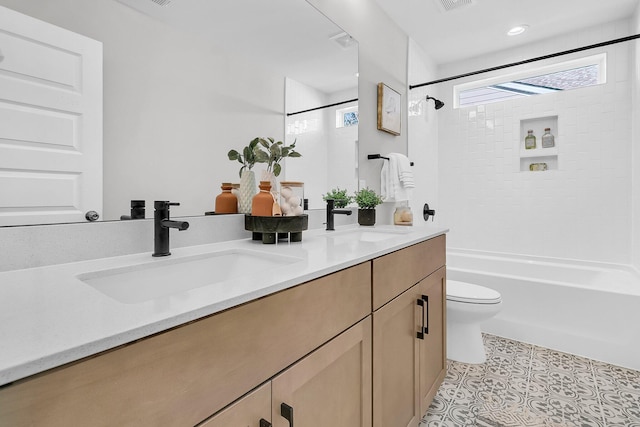 full bathroom featuring tile patterned flooring, vanity, tiled shower / bath combo, and toilet