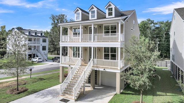 raised beach house with a porch, a balcony, a garage, and a front lawn