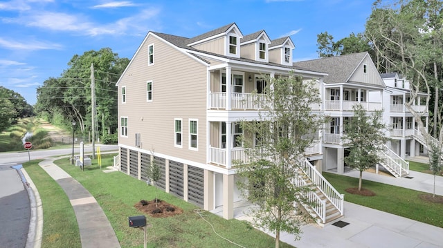 view of home's exterior with a balcony and a yard