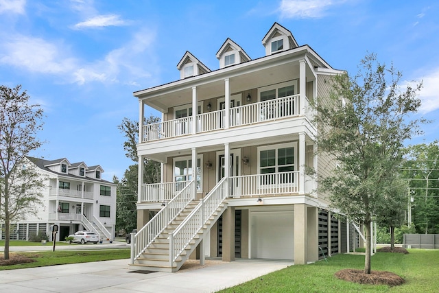 beach home with a garage, a front yard, and covered porch