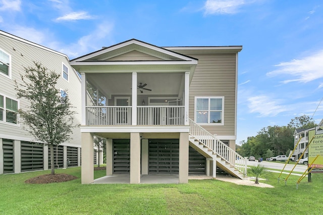 back of property featuring a patio, a sunroom, a yard, and ceiling fan