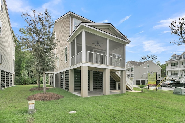 rear view of property with ceiling fan, a patio area, a sunroom, and a lawn