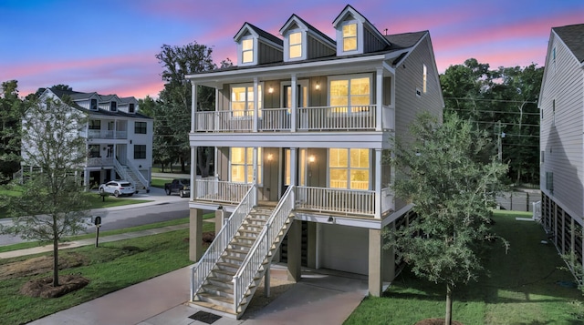 view of front of property featuring a garage, covered porch, and a lawn