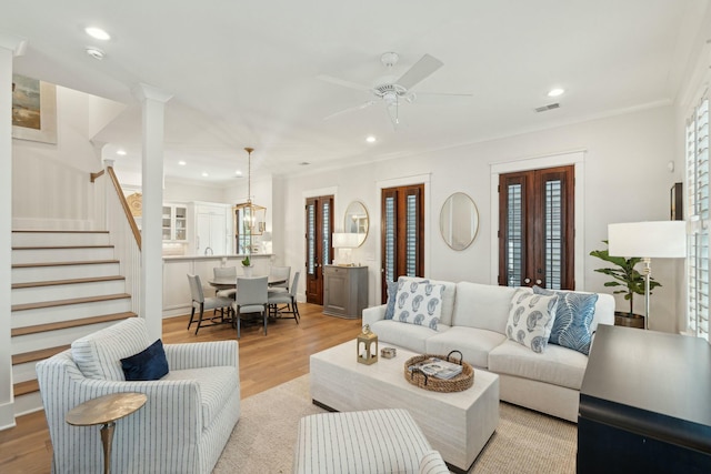 living room featuring recessed lighting, visible vents, light wood-style floors, and stairway