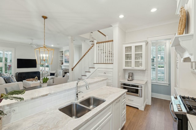 kitchen with hardwood / wood-style floors, crown molding, open floor plan, and a sink