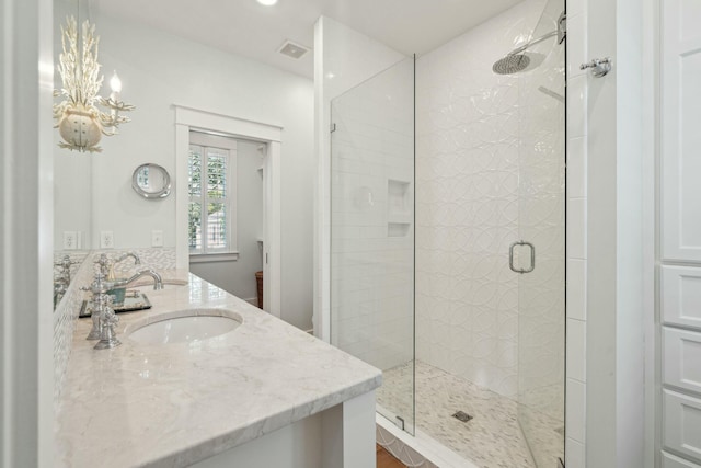 full bath featuring double vanity, visible vents, a stall shower, and a sink