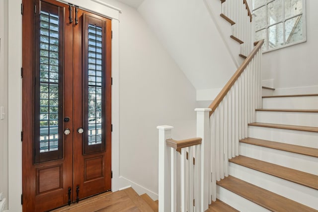 entrance foyer featuring stairs, light wood-style flooring, and baseboards