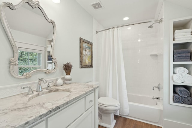 full bath featuring visible vents, toilet, shower / tub combo with curtain, wood finished floors, and vanity