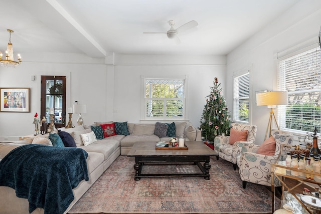 living room featuring ceiling fan with notable chandelier