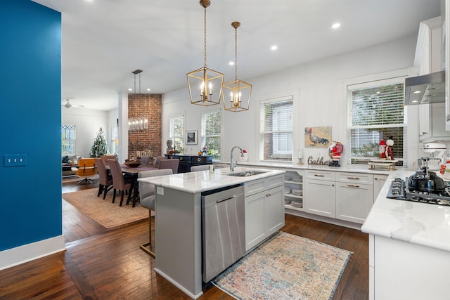 kitchen featuring dishwasher, sink, an island with sink, decorative light fixtures, and white cabinets