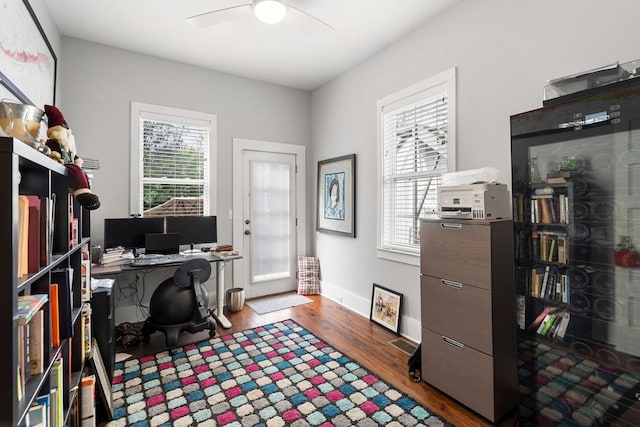 home office with ceiling fan, dark hardwood / wood-style flooring, and a healthy amount of sunlight