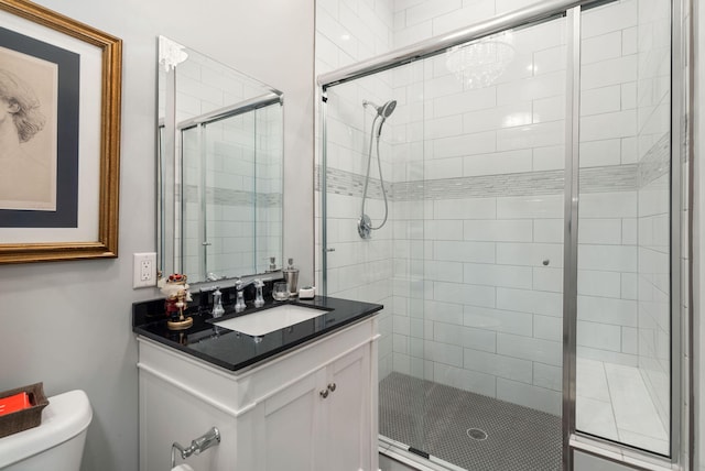 bathroom with vanity, a shower with shower door, and toilet