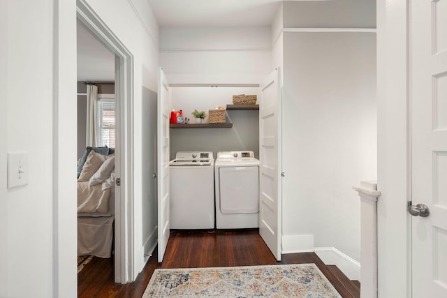 clothes washing area with washing machine and dryer and dark hardwood / wood-style floors