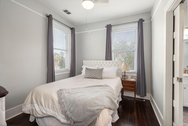 bedroom featuring multiple windows, dark hardwood / wood-style floors, and ceiling fan