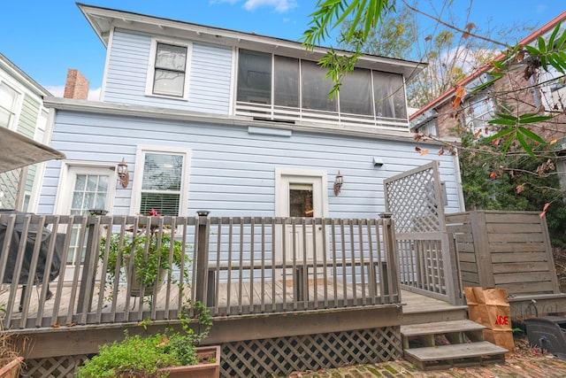 rear view of house with a wooden deck and a sunroom