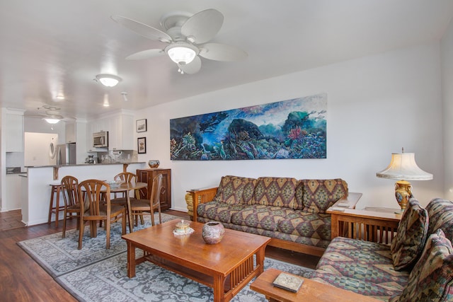 living room featuring baseboards, wood finished floors, and a ceiling fan