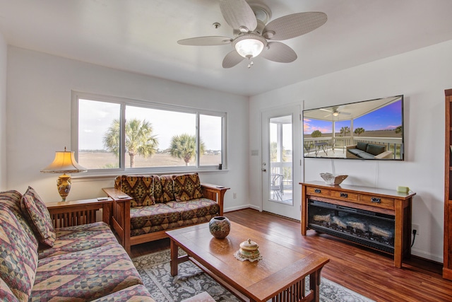 living room with baseboards, a ceiling fan, and wood finished floors