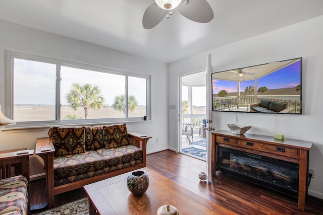 living room with baseboards, wood finished floors, and ceiling fan