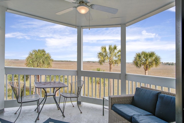 sunroom with a rural view, plenty of natural light, and ceiling fan