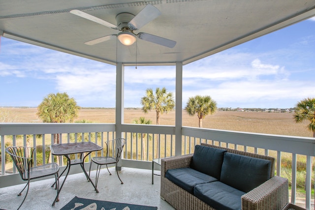 sunroom / solarium featuring plenty of natural light, a rural view, and ceiling fan