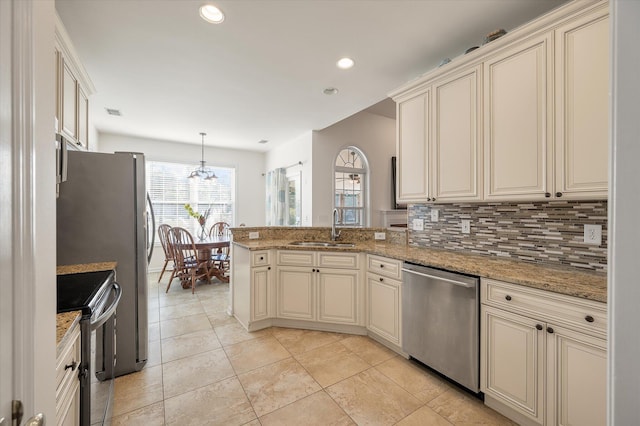 kitchen with stainless steel appliances, sink, and cream cabinetry