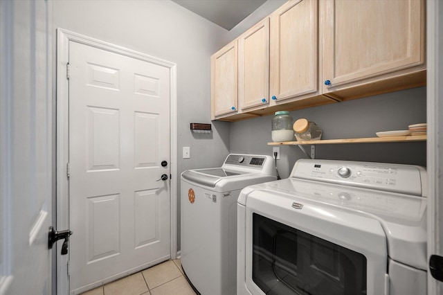 washroom featuring independent washer and dryer, cabinets, and light tile patterned floors