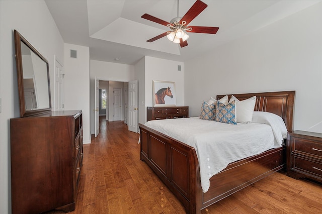 bedroom featuring a raised ceiling, hardwood / wood-style flooring, and ceiling fan