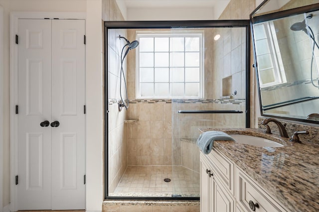 bathroom featuring vanity and a shower with door