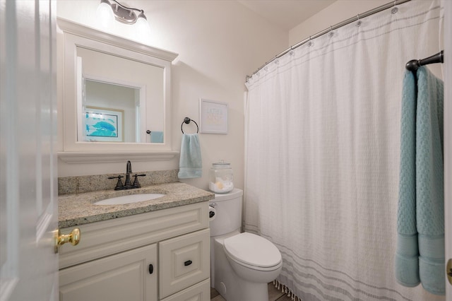 bathroom featuring vanity, curtained shower, and toilet